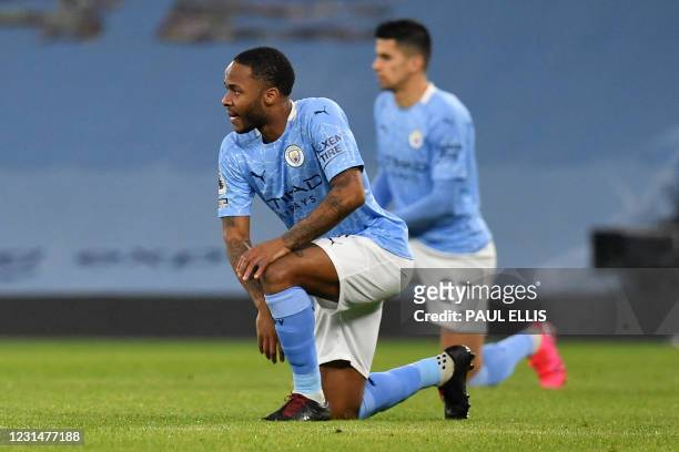 Manchester City's English midfielder Raheem Sterling and Manchester City's Portuguese defender Joao Cancelo take the knee in support of the No Room...