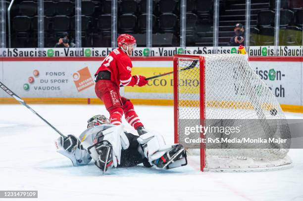 Christoph Bertschy of Lausanne HC scores a goal against Goalie Reto Berra of HC Fribourg-Gotteron during the Swiss National League match between...
