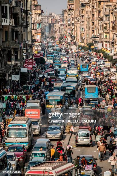 This picture taken on February 22, 2021 shows a view of vehicles stuck in a traffic jam amidst street vendors and pedlars in the central Attaba...