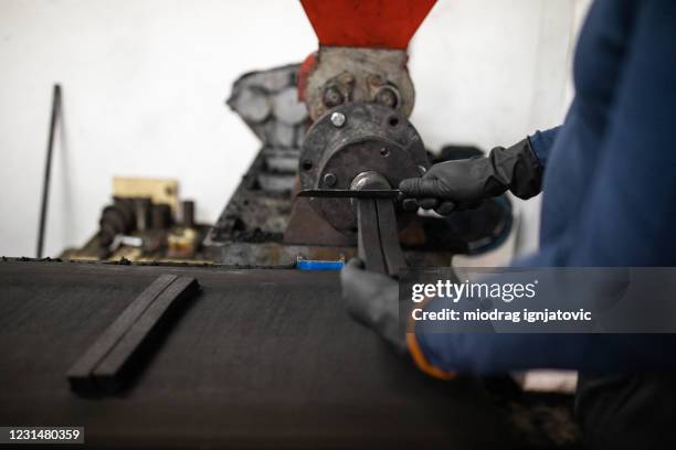 werknemer met beschermende handschoenen die aan transportband in fabriek van kokosskool voor waterpijp werken - briquet stockfoto's en -beelden