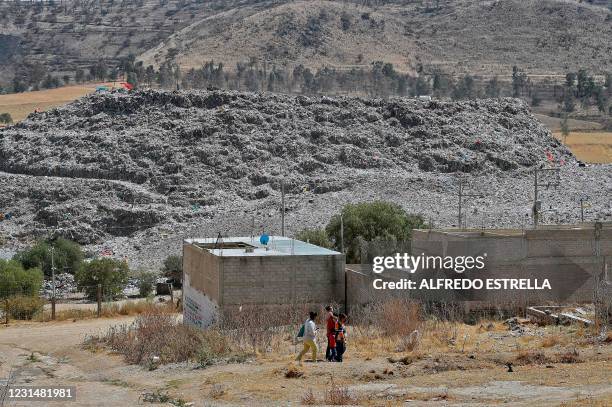 Family walks at the Escalerillas neighborhood with the municipal garbage dump in the background in Chimalhuacan, Mexico state, Mexico, on February...
