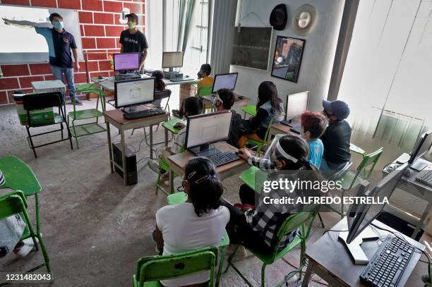 Teacher of the Utopia civil association gives a computer science lesson to local children at the Escalerillas neighborhood in Chimalhuacan, Mexico...
