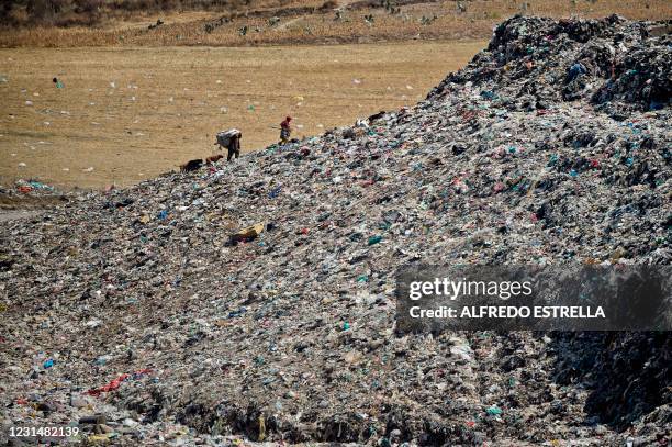 Scavengers walk at the municipal garbage dump in Chimalhuacan, Mexico state, Mexico, on February 24, 2021. - The COVID-19 pandemic made schools close...