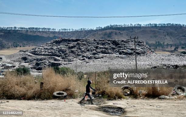 Child walks at the Escalerillas neighborhood with the municipal garbage dump in the background in Chimalhuacan, Mexico state, Mexico, on February 24,...