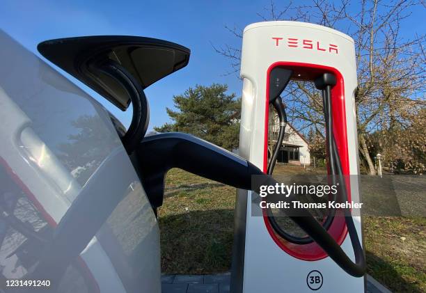 Tesla Model 3 plugged in and charging at a Supercharger rapid battery charging station for electric vehicles in Bersteland, Germany, on March 02,...
