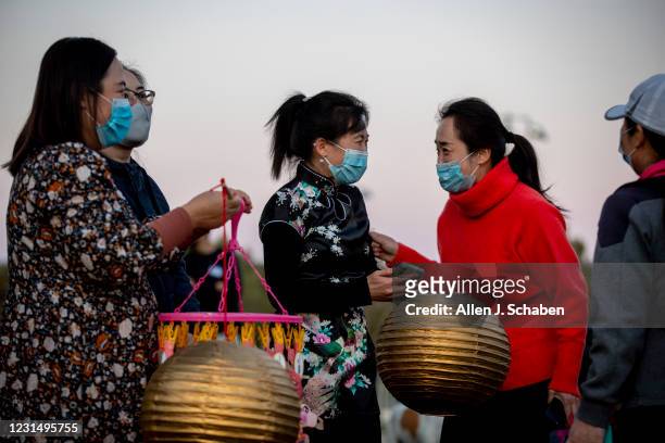 February 26: People hold lanterns as fellow neighbors of an Asian-American family that was harassed and community members put on a Lantern Festival...