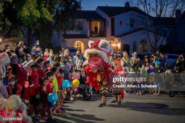 February 26: The Qing Wei Lion and Dragon Dance Cultural Troupe performs a lion dance as fellow neighbors of an Asian-American family that was...