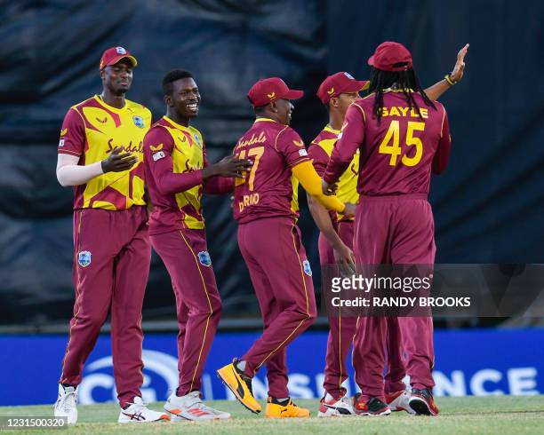 Kevin Sinclair and Jason Holder of West Indies celebrates the dismissal of Danushka Gunathilaka of Sri Lanka during a T20i match between Sri Lanka...