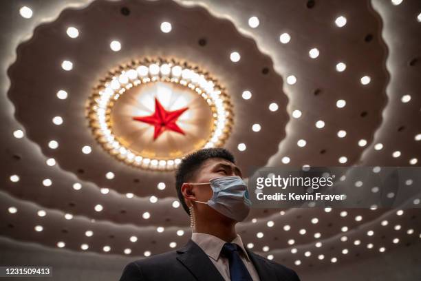 Security guard wears a protective mask as he guards at the opening session of the Chinese People's Political Consultative Conference at the Great...
