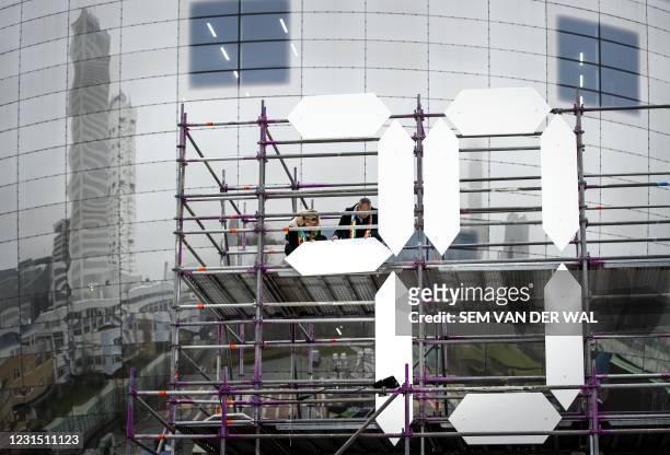 Councillor Said Kasmi and Sharon change the countdown clock of the Eurovision Song Contest in Rotterdam, on March 4, 2021. - The clock counts back...