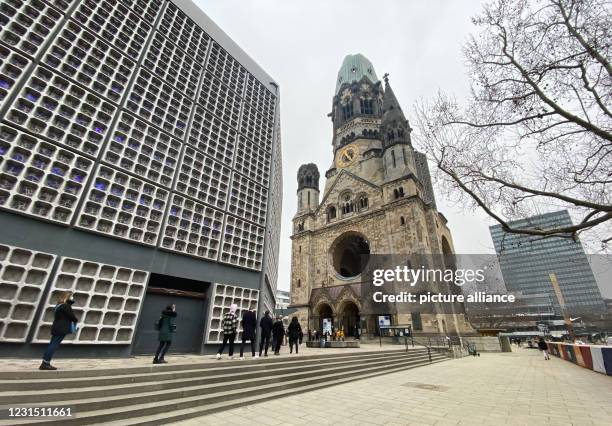 March 2021, Berlin: People stand in a queue in front of the entrance to the memorial hall of the Kaiser Wilhelm Memorial Church at Breitscheidplatz....