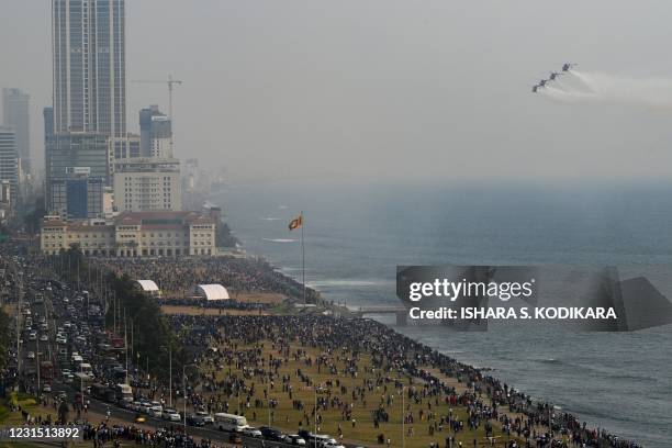 People watch as Indian Air Force's Advanced Light Helicopter aerobatic team 'Sarang' performs during the 70th anniversary celebrations of the Sri...