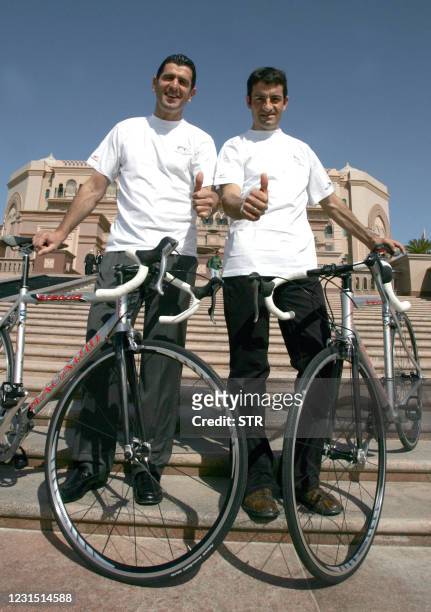 Spanish Melchor Mauri and Abraham Olano pose with their bicycles outside the Emirates Palace hotel in Abu Dhabi 28 February 2007. The Abu Dhabi...