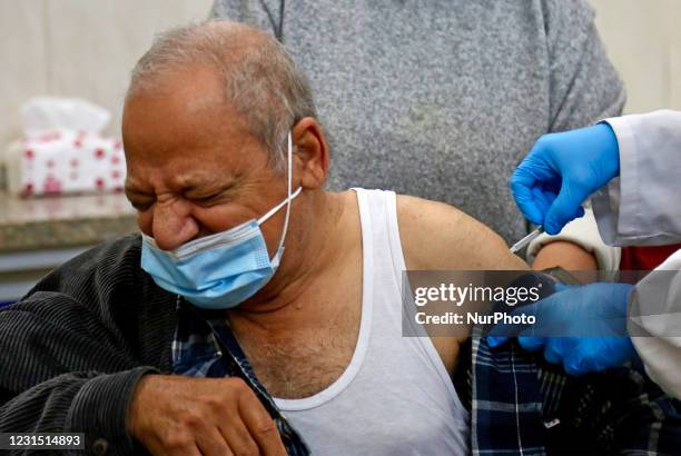 An Egyptian medical worker administers help people to receiving anOxford-AstraZeneca Covid-19 vaccine on March 4, 2021 at Qattameya's medical center...