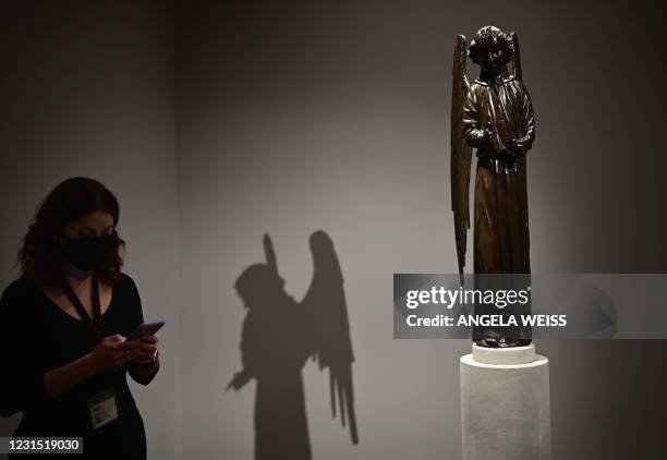 Person looks at her phone next to Jean Barbet's "Angel" during the Frick Collection opening press preview at Frick Madison, the Marcel Breuer...