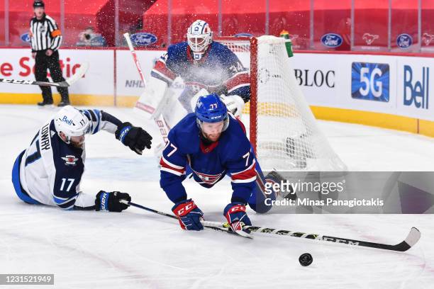 Adam Lowry of the Winnipeg Jets and Brett Kulak of the Montreal Canadiens fall as they chase the puck during the first period at the Bell Centre on...