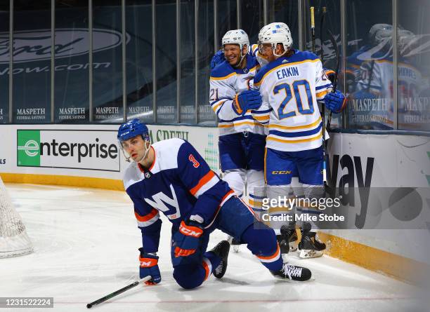 Taylor Hall of the Buffalo Sabres is congratulated by Kyle Okposo and Cody Eakin after scoring a goal as Adam Pelech reacts during the second period...