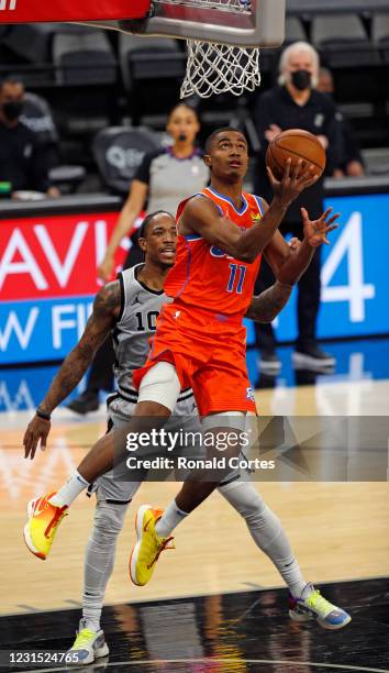 Theo Maledon of the Oklahoma City Thunder drives past DeMar DeRozan of the San Antonio Spurs in the second half at AT&T Center on March 4, 2021 in...