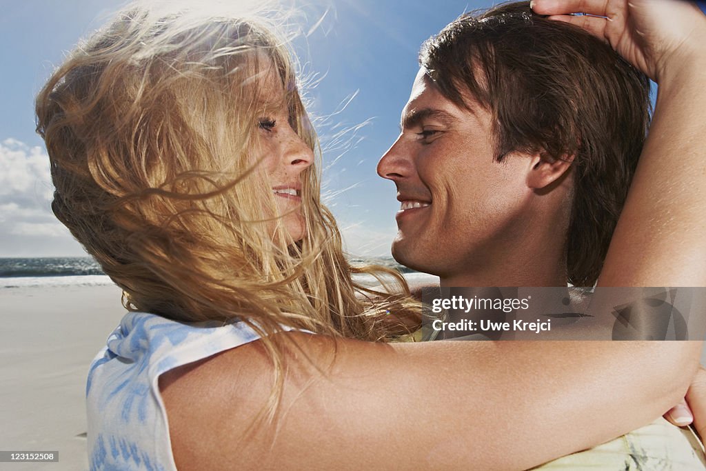 Young couple embracing and smiling, close up