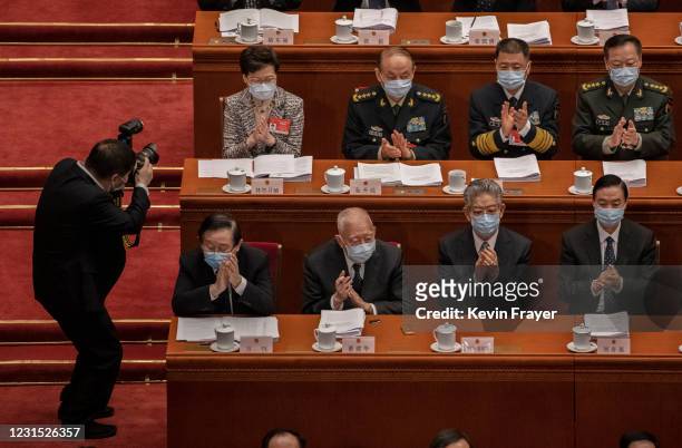 Hong Kong Chief Executive Carrie Lam, top left, is photographed as she applauds with other lawmakers during the opening session of the National...