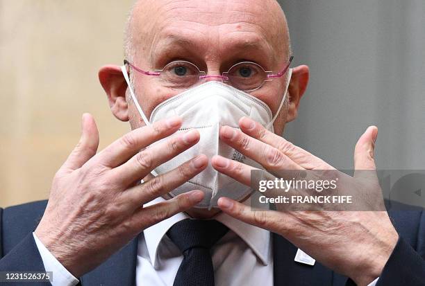 French Rugby Federation President Bernard Laporte gestures towards his protective face mask as he answers journalists questions after the examination...