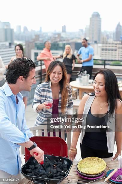 group of young adults grilling at rooftop party - asian person bbq stock-fotos und bilder
