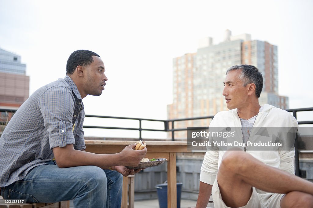 Two Young Adult Men Talking at Rooftop Party