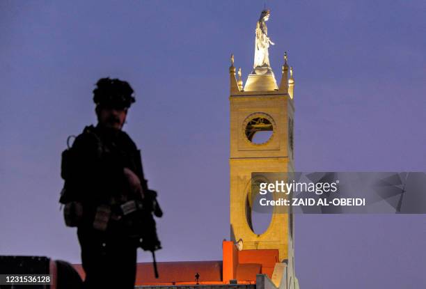 Fighter of the Nineveh Plain Protection Units , an Assyrian Christian militia, stands guard outside the Syriac Catholic Church of the Immaculate...