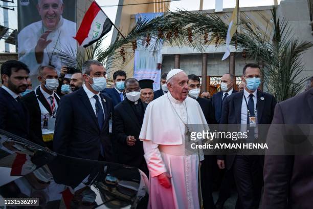 Security personnel surround Pope Francis as he leaves Baghdad's Syriac Catholic Cathedral of Our Lady of Salvation at the start of the first ever...