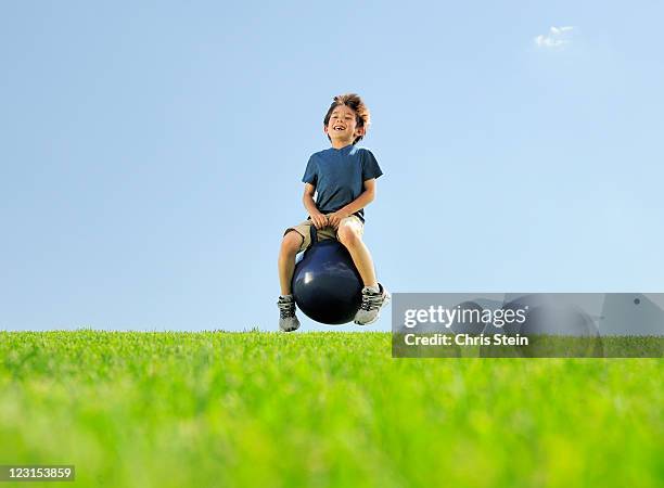 young boy bouncing on a hill - balls bouncing stock pictures, royalty-free photos & images