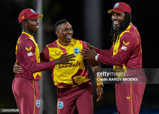 Kevin Sinclair , Dwayne Bravo and Chris Gayle of West Indies celebrate the dismissal of Pathum Nissanka of Sri Lanka during the 2nd T20i match...