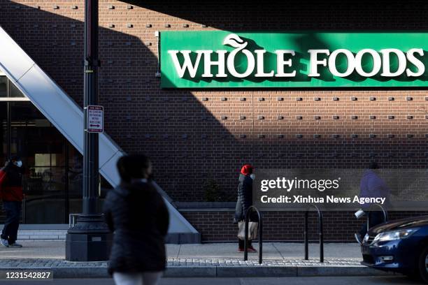 March 5, 2021 -- People walk past a Whole Foods market in Washington, D.C., the United States, March 5, 2021. U.S. Employers added 379,000 jobs in...