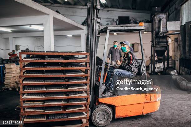 mann reitet gabelstapler in kohle für hookah in fabrik - briketts stock-fotos und bilder