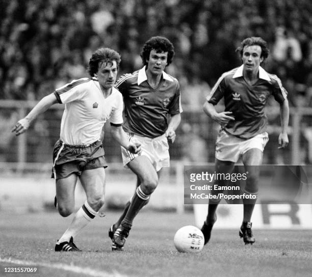 Steve Coppell of England moves away with the ball as Chris McGrath and Sammy McIlroy of Northern Ireland give chase, during a British Home...