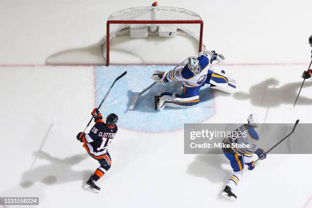 Cal Clutterbuck of the New York Islanders scores a goal past Carter Hutton of the Buffalo Sabres during the second period at Nassau Coliseum on March...