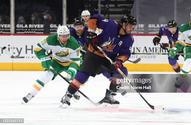 Niklas Hjalmarsson of the Arizona Coyotes skates with the puck as Zach Parise of the Minnesota Wild defends during the first period of the NHL hockey...