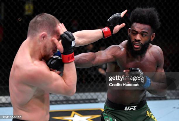 In this handout image provided by UFC, Aljamain Sterling punches Petr Yan of Russia in their UFC bantamweight championship fight during the UFC 259...