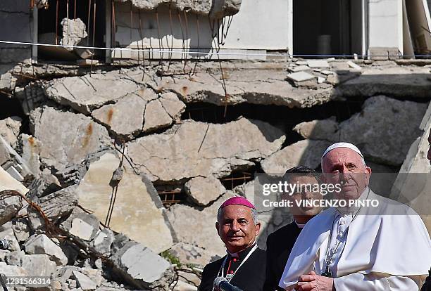 Pope Francis , accompanied by the Chaldean Catholic Archbishop of Mosul Najib Michaeel Moussa , looks on at a square near the ruins of the Syriac...