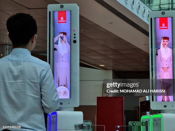 Passenger crosses a newly deployed fast-track gate that uses face and iris-recognition technologies at Dubai international airport, on March 7, 2021....