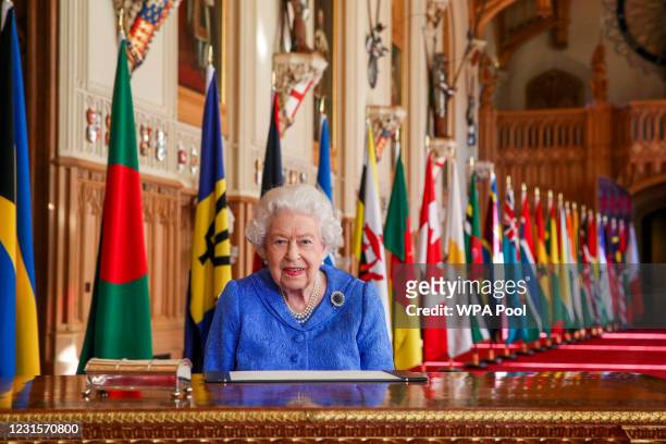 In this undated image released on March 7 Queen Elizabeth II signs her annual Commonwealth Day Message in St George's Hall at Windsor Castle, to mark...