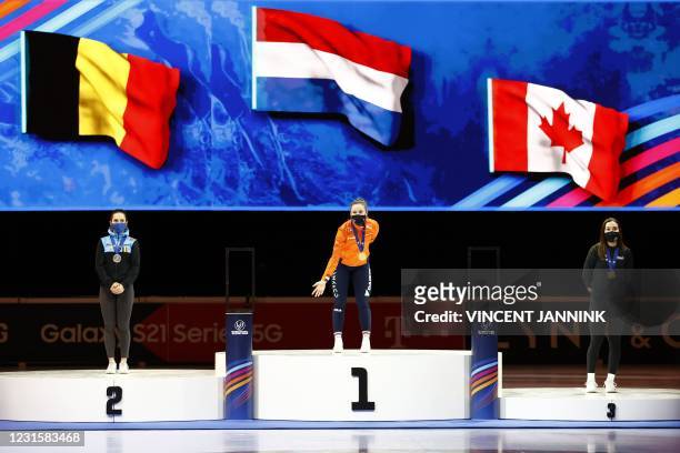 Netherlands' gold medallist Suzanne Schulting reacts alosng side silver medallist Belgium's Hanne Desmet and bronze medallist Canada's Courtney...