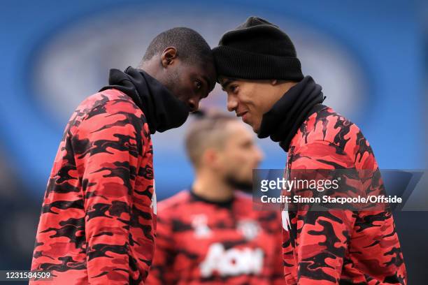 Eric Bailly of Manchester United goes head-to-head with Mason Greenwood of Manchester United before the Premier League match between Manchester City...