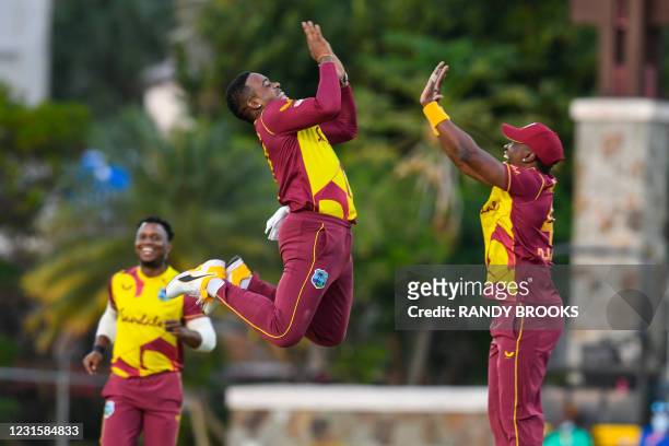 Fabian Allen and Dwayne Bravo of West Indies celebrate the dismissal of Danushka Gunathilaka of Sri Lanka during the 3rd and final T20i match between...