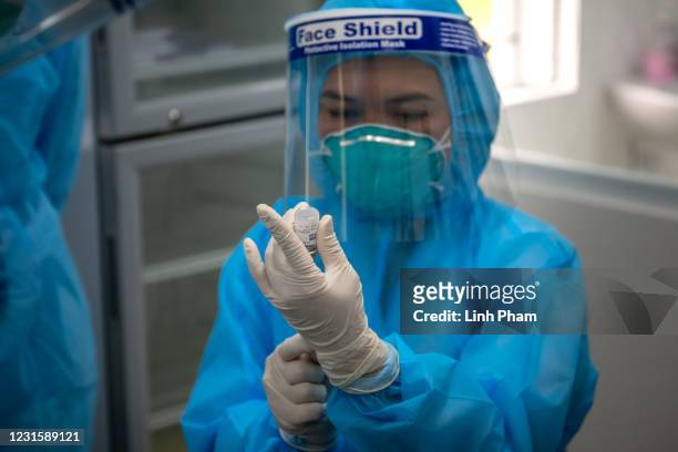 Health worker prepares a dose of AstraZeneca COVID-19 vaccine at National Hospital for Tropical Diseases on March 8, 2021 in Hanoi, Vietnam. Vietnam...