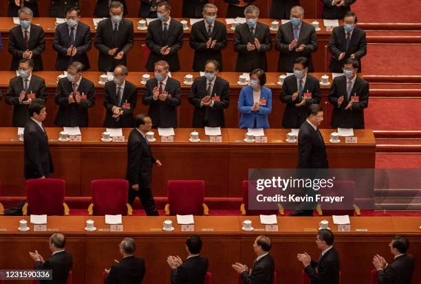 Chinese President Xi Jinping, bottom right, and Premier Li Keqiang, second right, Li Zhansu, third right, are applauded by members of the government...