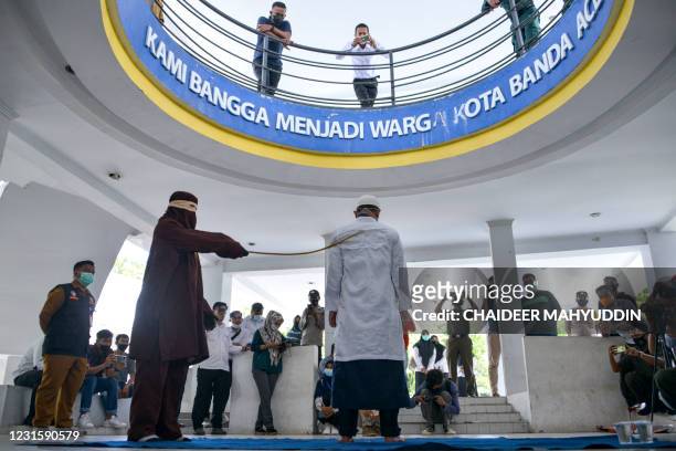 Man is given lashes during a public caning as punishment under Aceh province's Sharia laws for being caught in close proximity with his girlfriend,...