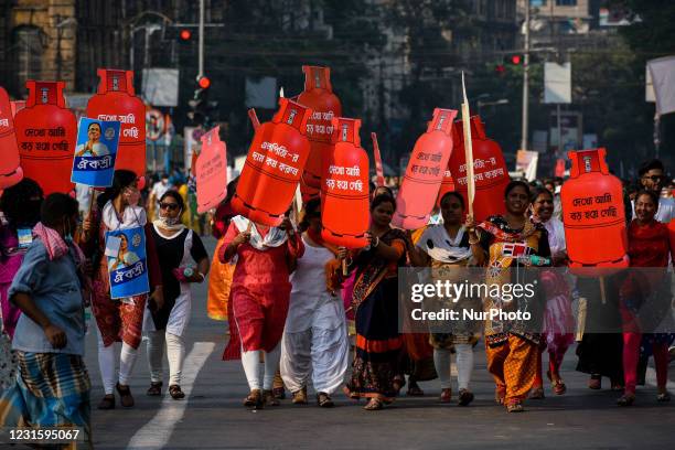 Female Supporters of Trinamool congress carrying a cutout of gas cylinder with protest slogan written on it during a rally taken out on the occasion...