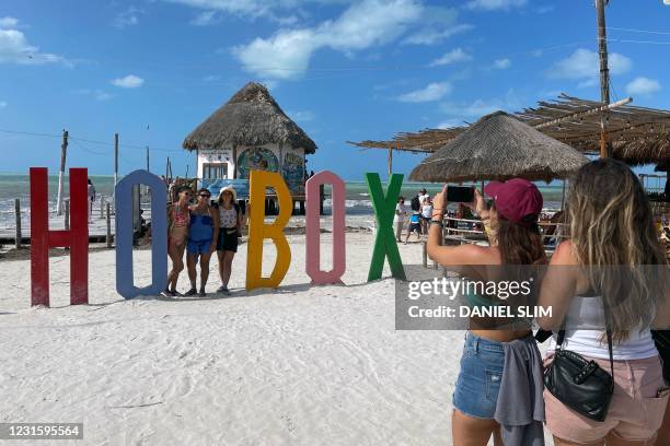 Tourists pose for a picture in Holbox Island, Mexico, on March 7, 2021. - Holbox is famous for its large congregation of whale sharks and as ideal...