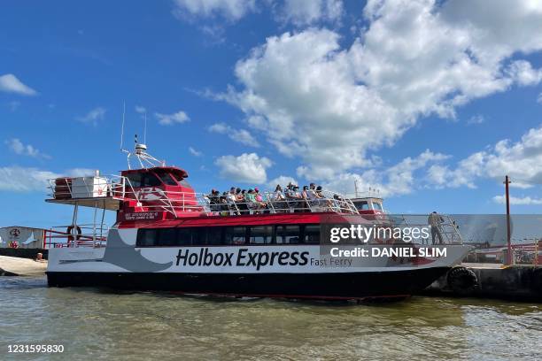 Tourists board a ferry bound to Holbox Island in Chiquila, Quintana Roo state, Mexico on March 7, 2021. - Holbox is famous for its large congregation...