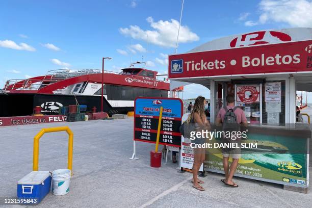 Tourists buy tickets to board a ferry bound to Holbox Island in Chiquila, Quintana Roo state, Mexico on March 7, 2021. - Holbox is famous for its...